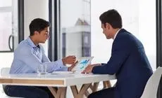Two business pros discussing B2B digital marketing strategies using performance data in Bangalore